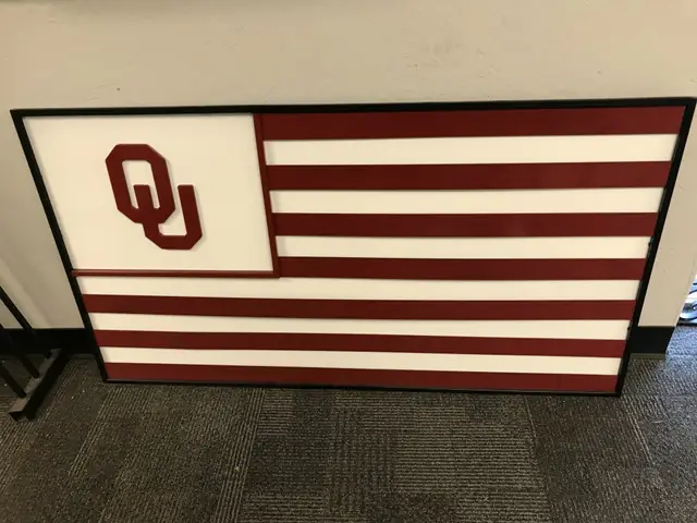 A fabricated steel OU flag in crimson and cream, built in the Cook's shop