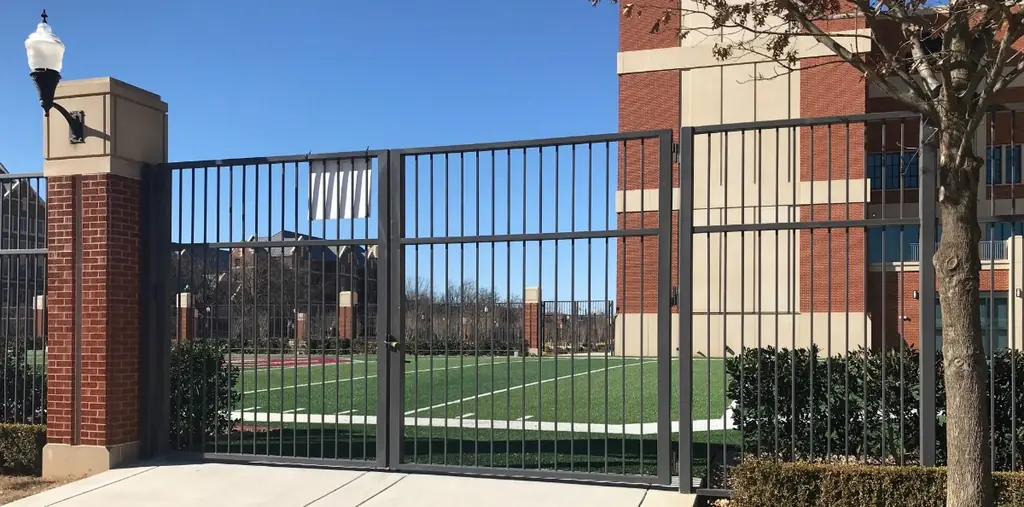A tall picket iron gate and fence fabricated by Cook's Fence and Iron at the University of Oklahoma stadium